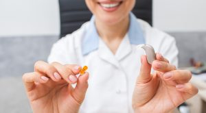 audiologist-hearing aids-repairs Audiologist holding hearing aids.